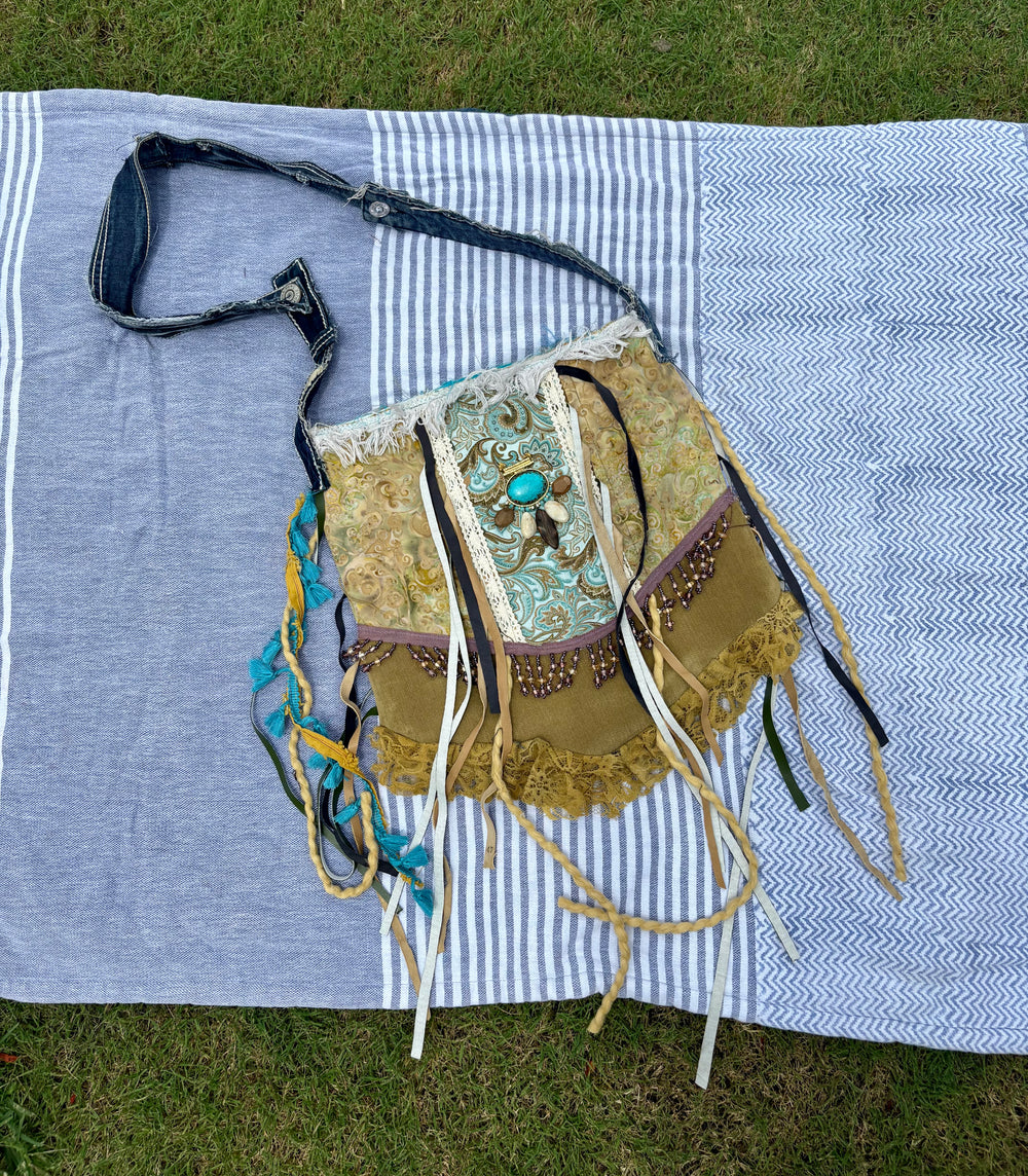 large dark green shoulder bag with multicolor accents, fringe, lace, and stones sewn on