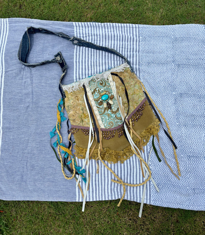 large dark green shoulder bag with multicolor accents, fringe, lace, and stones sewn on