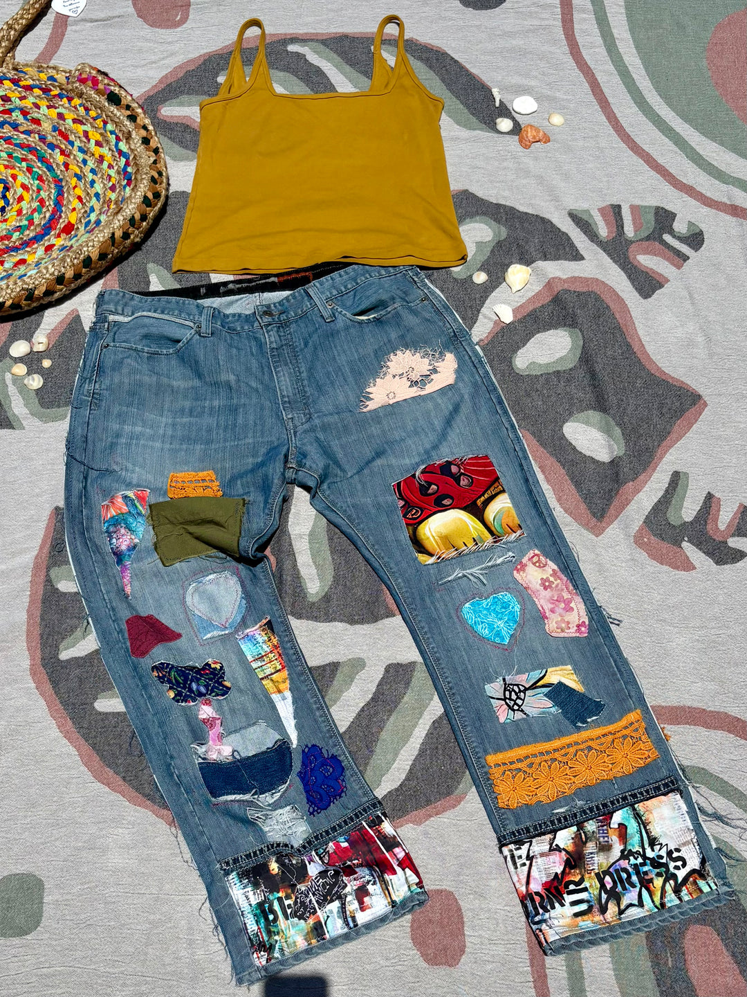 medium wash baggy jeans with patchwork of various colors, patterns, and materials.