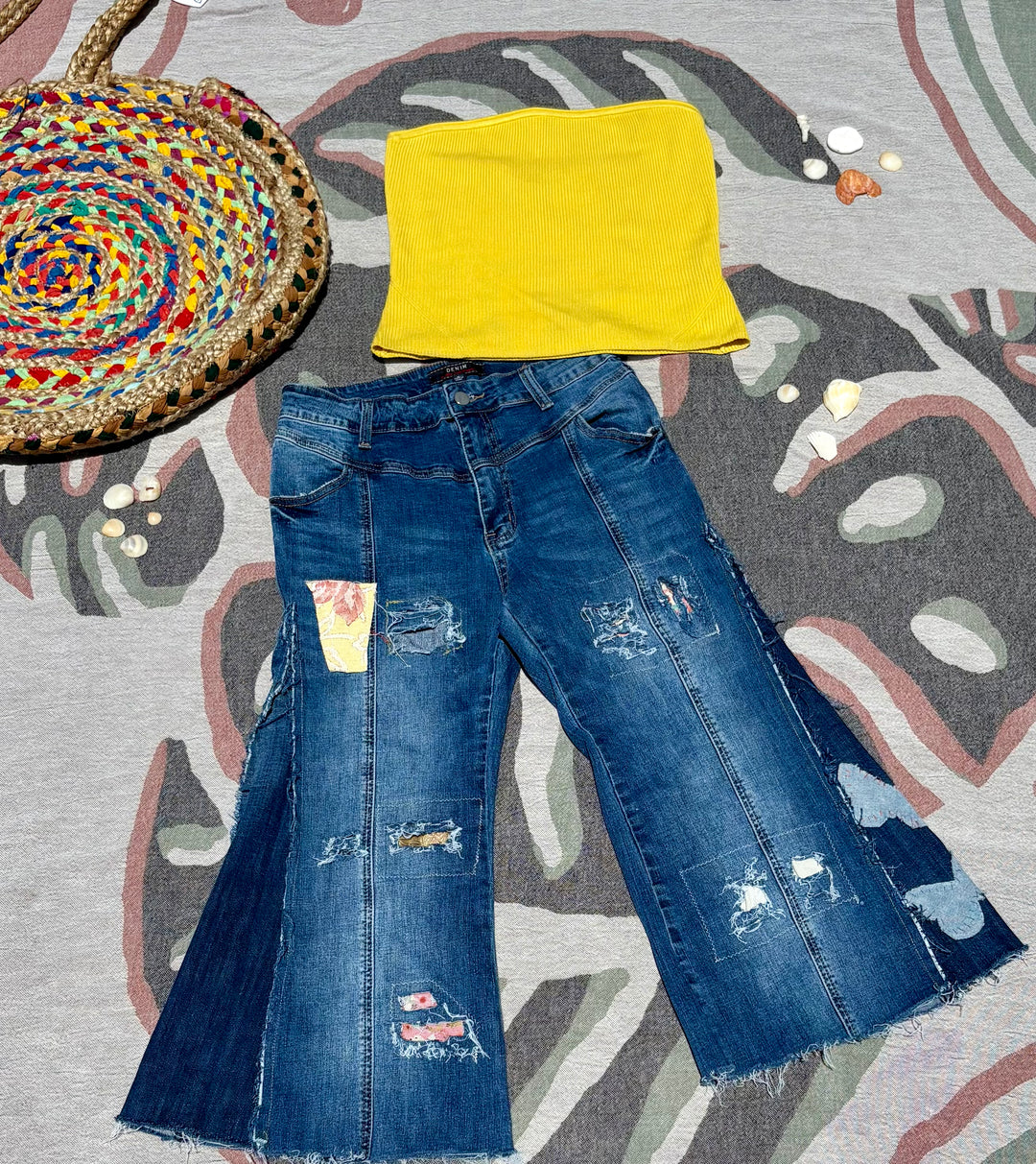 cropped and flared dark denim jeans with various colorful patchwork and butterfly shaped patches.